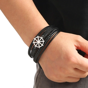 Men's multi-layer black leather bracelet with silver rudder charm on wrist