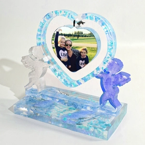 Detail of heart resin photo frame with blue dried flowers and double angel accents