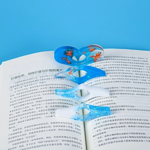 Macro shot of resin page holders with gold foil inlays placed on an open book