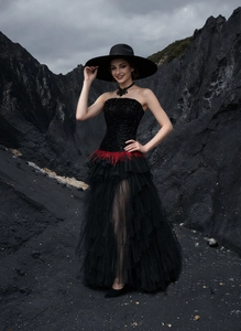 Detail of black sequined strapless dress with vibrant red feather waist accent