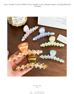 Detail of large acetate flower hair claw clips with rhinestones in various colors