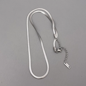 Macro shot of silver herringbone chain detail featuring lobster clasp and 18KGP engraving