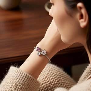 Close-up of vintage silver butterfly cuff bracelet featuring pink zircon and shell inlay