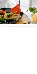 Red silicone spatula with stainless steel handle frying chicken breast in a pan