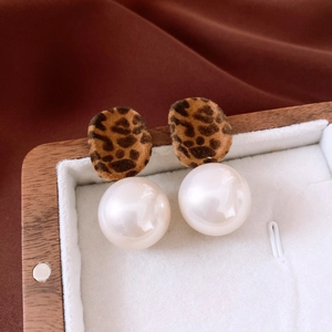 Detail of leopard print flocked fabric and large faux pearl on vintage style earrings