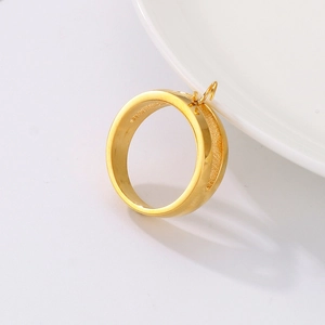 Polished gold stainless steel hollow ring with a top loop shown on white ceramic