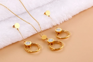 Detailed view of golden double-circle necklace and earrings set with crystal inlay