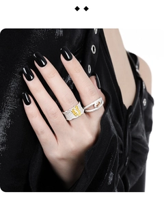 Macro detail of silver rings with organic textures, amber stone, and gold plating