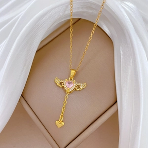 Detail der Goldkette mit rosa Herz-Edelstein und beweglichen Engelsflügeln auf Seide