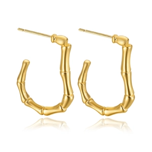 Macro view of gold-plated bamboo-shaped U-style earrings with detailed metal texture