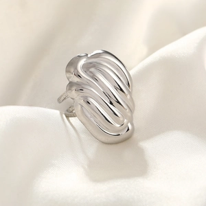 Detailed view of silver hammered stainless steel ring on white silk background