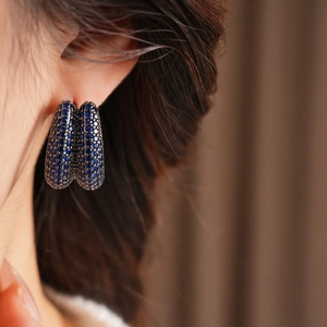 Detail of vintage blue zircon double layer U-shaped earrings worn by a model