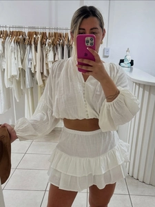 Two-piece white cotton set with puff sleeve crop top and tiered ruffle mini skirt