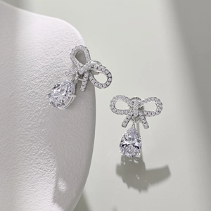 Macro shot of S925 sterling silver bowknot earrings with pear-shaped zircon drops