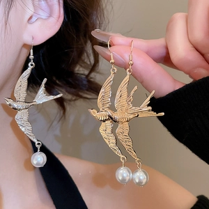Nahaufnahme der Schwalben-Ohrringe mit Perle, erhältlich in Silber und Gold Ausführung