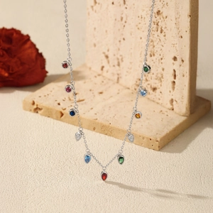 S925 sterling silver necklace with colorful gemstones displayed on a minimalist stone stand