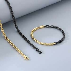 Detail of two-tone gold and black stainless steel necklace and bracelet set with lobster clasp