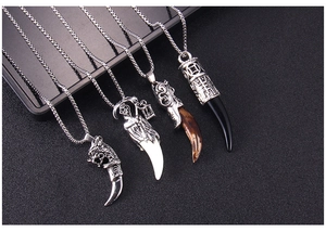Detail of four retro stainless steel necklaces featuring wolf tooth and reaper pendants