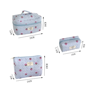 Three-piece set of blue striped quilted cosmetic bags with strawberry prints in various sizes