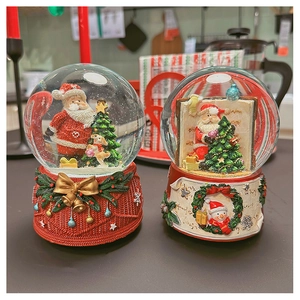 Detailed view of Christmas snow globe music boxes with Santa and Snowman resin base