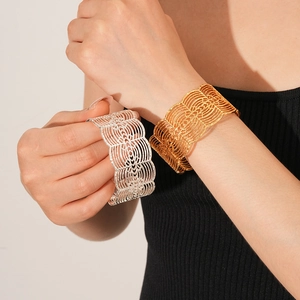 Detail von breiten Manschettenarmbändern mit hohlem geometrischem Muster in Gold und Silber