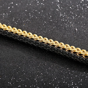 Makroaufnahme von Herren-Lagenarmband mit goldener Metallkette und schwarzem Lederband