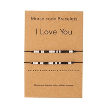 Dettaglio dei braccialetti in codice Morse su carta kraft con messaggi I Love You