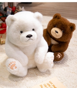 Close-up of plush teddy bear paws with embroidered details and soft faux fur texture
