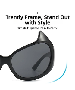 Detail view of black devil horn sunglasses with dark grey lenses and gothic frame design