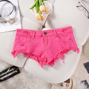 Dettaglio degli shorts in denim rosso rosa con bordi sfilacciati e texture invecchiata