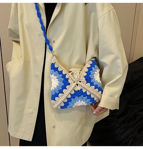 Detail of hand-crocheted sunflower shoulder bag showing granny square texture and blue yarn