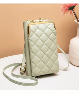 Detail of light green quilted mobile phone bag with golden kiss lock and floral decor