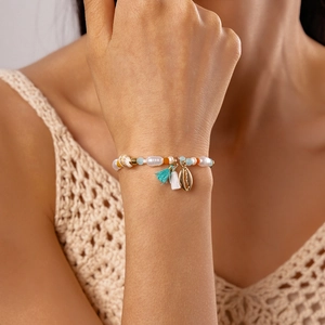 Detail of beach style bracelet featuring irregular pearls, sea shells and colorful beads