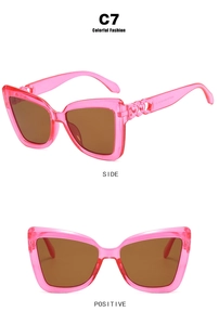 Pink cat eye sunglasses with brown lenses and hollow flower temple details side view