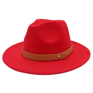 Détail d'un chapeau fedora en laine rouge avec une ceinture en cuir brun et rivet doré