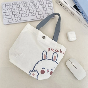 Detail of canvas tote bag with cute rabbit print and metal snap button closure