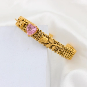 Detail of gold woven bangle featuring pink heart gemstone and romantic rose motifs