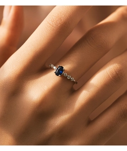 Detailaufnahme eines Silberrings mit ovalem blauem Saphir und Pavé-Diamanten