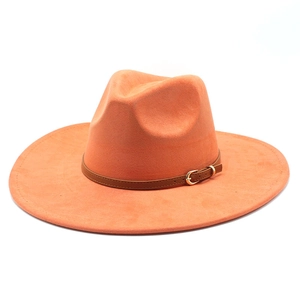 Detail of orange suede fedora hat featuring a brown leather band and gold metal buckle