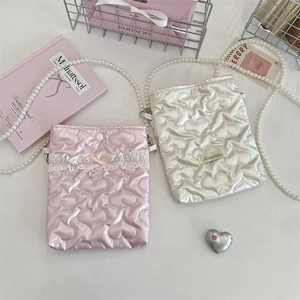 Dettaglio mini borsa a tracolla trapuntata a cuore con tracolla di perle e fiocco