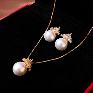Elegant gold crown zircon pendant necklace and pearl earrings set in a velvet jewelry box