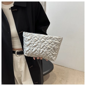 Detail of silver heart-quilted clutch bag showing metallic texture and stylish design