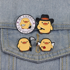 Lot de quatre pin's émaillés canards mignons affichés sur une poche de veste en jean