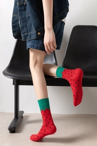 Close-up of cotton mid-calf socks with red strawberry pattern and green leaf cuffs