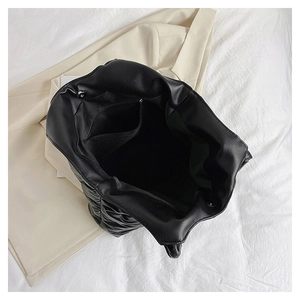 Internal view of black quilted tote bag showing magnetic closure and inner pocket