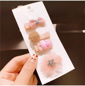 Close-up of set of 4 pink fabric hair clips with bow, heart, and star designs for kids