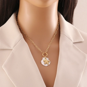 Golden starfish and shell pendant necklace on model wearing beige blazer suit