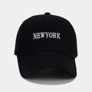 Dettaglio del ricamo bianco NEW YORK su un cappello da baseball in cotone nero