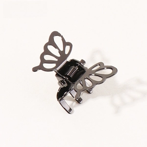 Detailed macro view of small black butterfly hair claw clip with cutout metal design