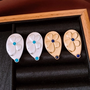 Detailed close-up of vintage flower drop earrings with turquoise and navy stones